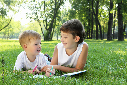 Photo: Children in the park reading a book Children in the park reading a book