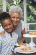 Older woman and granddaughter having pie