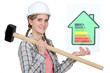 Woman holding energy rating information and sledge-hammer