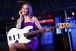 Young guitar player performing in night club