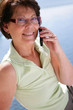 canvas print picture - Middle-aged woman making call outdoors