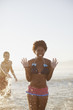 Friends playing in waves on beach