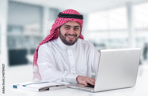 Photo: arabian businessman using laptop in his office arabian businessman using laptop in his office