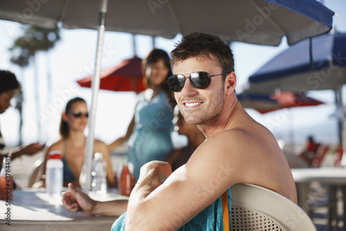 Photo: Smiling man sitting at table outdoors Smiling man sitting at table outdoors