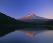 Forest and mountaintop reflected in still lake