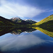 Photo: Mountains and sky reflected in still lake Mountains and sky reflected in still lake