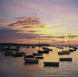 Empty boats in still harbor at sunset
