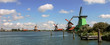 Panoramic view on river and windmills.