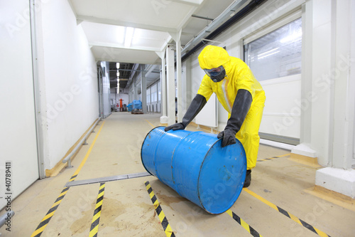 Photo: technician rolling the barrel with toxic substance technician rolling the barrel with toxic substance