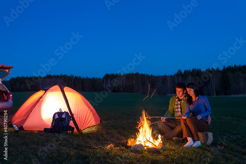 Foto: Tent camping car couple sitting by bonfire Tent camping car couple sitting by bonfire