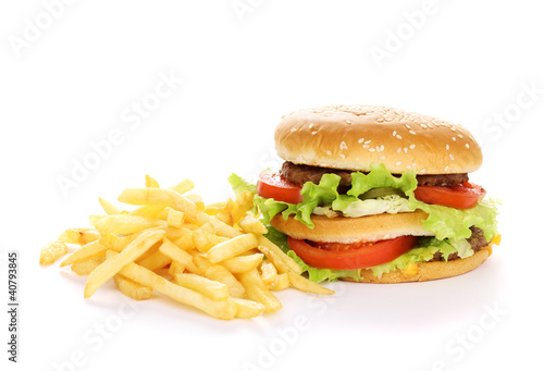 Photo: Big and tasty hamburger and fried potatoes isolated on white Big and tasty hamburger and fried potatoes isolated on white