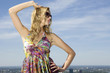 beautiful girl in sunglasses on background blue sky