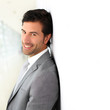 Businessman standing on white wall- profile view
