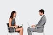 canvas print picture - Business people sitting face to face on grey background