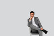 Businessman sitting on chair on grey background