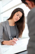 Businesswoman writing on document after meeting