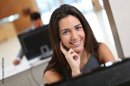 Photo: Smiling office worker at ther desk Smiling office worker at ther desk