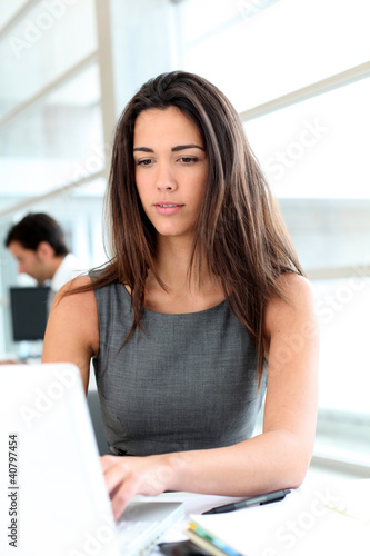 Photo: Attractive businesswoman working on laptop computer Attractive businesswoman working on laptop computer