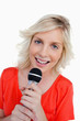 Smiling teenager singing in a cordless microphone
