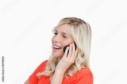 Foto: Woman laughing while talking on a cellphone Woman laughing while talking on a cellphone