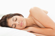 Foto: A woman sleeping on a bed, her head resting on the pillow, her e A woman sleeping on a bed, her head resting on the pillow, her e