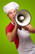 portrait of young cook man screaming with megaphone over green b portrait of young cook man screaming with megaphone over green b