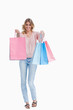 A woman is standing holding up shopping bags