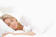 Woman sleeping in bed, with her arm resting slightly in front of