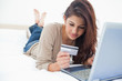 Photo: Woman looking at her credit card details as she uses her laptop Woman looking at her credit card details as she uses her laptop