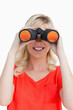 Smiling woman looking through binoculars
