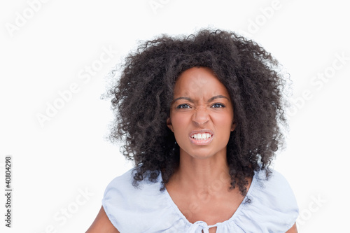 Photo: Young woman with curly hairstyle showing teeth to indicate her a Young woman with curly hairstyle showing teeth to indicate her a