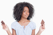 canvas print picture - Young woman holding two pieces of chocolate