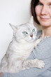 Middle age woman holding beautiful grey cat