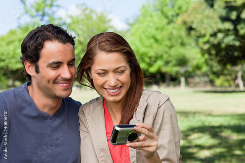 Photo: Woman and her friend looking at pictures on a camera Woman and her friend looking at pictures on a camera