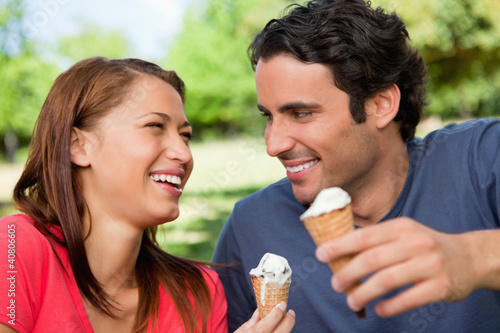 Photo: Two friends laughing while holding ice cream Two friends laughing while holding ice cream