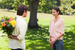 Woman smiling as her friend approaches her with flowers