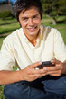 canvas print picture - Man looking ahead while writing a text message as he is sitting