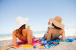 Photo: Back view of beautiful women sunbathing while sipping cocktails Back view of beautiful women sunbathing while sipping cocktails