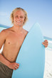Young smiling man standing upright while holding his perched sur