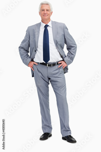 Photo: Portrait of a man in a suit with hands on hips Portrait of a man in a suit with hands on hips