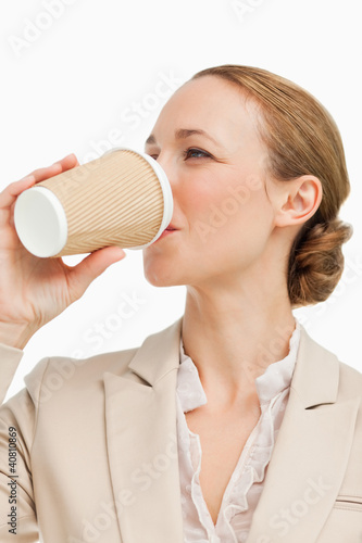 Photo: Businesswoman in a suit drinking a takeaway coffee Businesswoman in a suit drinking a takeaway coffee