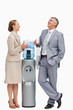 People in suit laughing next to the water dispenser