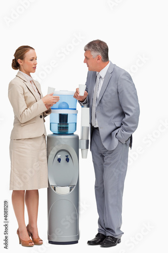 Photo: People in suit talking next to the water dispenser People in suit talking next to the water dispenser