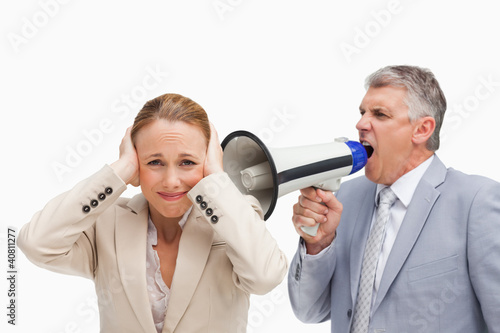 Photo: Businessman yelling with a megaphone after his colleague Businessman yelling with a megaphone after his colleague