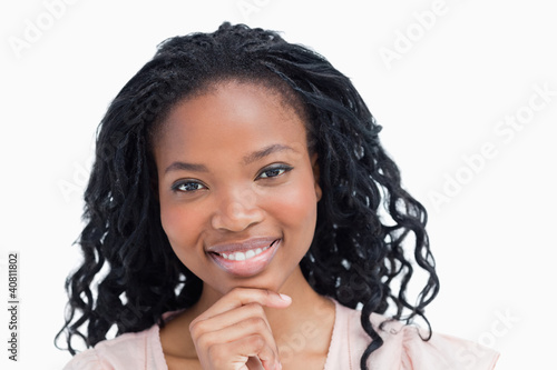 Photo: Head shot of a smiling young woman resting her head on her hand Head shot of a smiling young woman resting her head on her hand