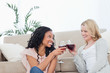 Foto: Two women smiling at each other are holding wine glasses Two women smiling at each other are holding wine glasses