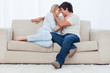 A happy couple are sitting down together embracing