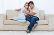 A couple sitting on a couch embracing each other