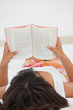 Rear view of a young woman reading a novel