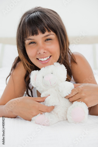 Photo: Portrait of a young woman playing with a teddy bear Portrait of a young woman playing with a teddy bear